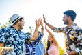 cheerful friends giving high five to each other outdoors in summer park Royalty Free Stock Photo