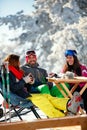 Cheerful friends having fun after skiing in resort with snow equipment Royalty Free Stock Photo