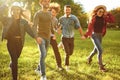 Cheerful friends are running in the park. Royalty Free Stock Photo