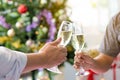 Cheerful Friends toasting sparkling wine. Close-ups hands of two friends toasting wine glass in the dinner party for celebrating