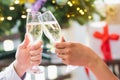 Cheerful Friends toasting sparkling wine. Close-ups hands of two friends toasting wine glass in the dinner party for celebrating