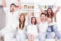 Cheerful friends watching football game on tv Royalty Free Stock Photo