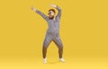 Cheerful funny eccentric fat man in good mood is dancing and fooling around on orange background.