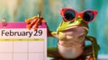 A cheerful funny Frog in sunglasses - a symbol of the day in a leap year, sits near a calendar with the date February 29