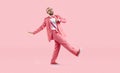 Cheerful, funny and humorous young man in pink suit takes step on pastel pink background.