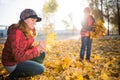 Cheerful and funny mother plays with yellow maple leaves Royalty Free Stock Photo