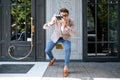 Cheerful funny photographer in round glasses taking pictures on street