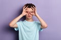 Cheerful funny young man making binoculars with fingers Royalty Free Stock Photo