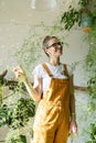 Cheerful gardener girl in home garden. Florist female enjoy caring of houseplants in greenhouse Royalty Free Stock Photo