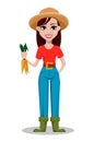 Cheerful gardener woman rancher holding fresh carrots