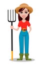 Cheerful gardener woman rancher holding pitchfork.