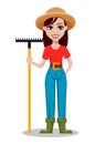 Cheerful gardener woman rancher holding rake.