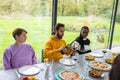 Friends Enjoying a Wine and Dine Experience in a Greenhouse Setting Royalty Free Stock Photo