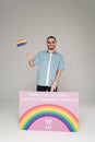 Cheerful gay man holding lgbt flag