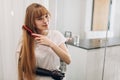 Cheerful ginger girl styling her hair Royalty Free Stock Photo