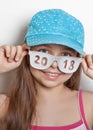 Cheerful girl in a baseball cap and glasses with the number 2018