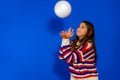 Cheerful girl catches the ball.Isolated on blue background Royalty Free Stock Photo