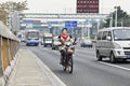 Cheerful girl on an electric bike on the road, Guangzhou, China