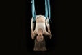 Cheerful girl gymnast does an aerial gymnastics exercise on sports hammock upside down. Woman practicing fly yoga