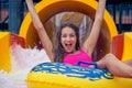 Cheerful girl with hands up having fun sliding in water park on inflatable ring Royalty Free Stock Photo