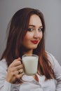 Cheerful girl holding milk mug in hand