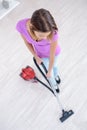 Cheerful girl hoovering in living room Royalty Free Stock Photo