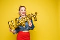 Cheerful girl with inflatable letters HAPPY.Stock photo portrait of attractive girl with red lips holding shining bright