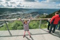 A cheerful girl on an observation deck in a sunny day over the view of Bergen, Norway Royalty Free Stock Photo