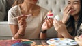 Cheerful girl painting Easter eggs while enjoying decorating with mother. Easter holidays and people concept. Royalty Free Stock Photo