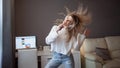 Cheerful girl with a phone and big headphones is dancing and singing. Holds the phone as a microphone. Royalty Free Stock Photo