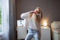 Cheerful girl with a phone and big headphones is dancing and singing. Holds the phone as a microphone. Royalty Free Stock Photo