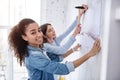 Cheerful girl posing while helping to hang a picture Royalty Free Stock Photo