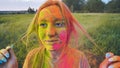 Cheerful girl posing smeared in multi-colored powder. Close-up face. Royalty Free Stock Photo