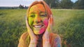 Cheerful girl posing smeared in multi-colored powder. Close-up face. Royalty Free Stock Photo
