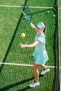 Cheerful girl practicing serve on a brand new outdoor tennis court. High angle. Royalty Free Stock Photo