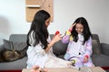 Cheerful girl pretending to be doctor and treating her young sister as patient. Royalty Free Stock Photo