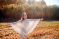 Cheerful girl with raised hands on the field in warm autumn season. Royalty Free Stock Photo