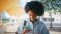 Cheerful girl reading sms looking smartphone screen on sunny street close up.