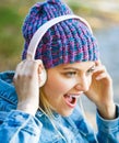 Cheerful girl rejoicing listening music in headphones smiling. Girl listens to music in headphones. Listening to music Royalty Free Stock Photo