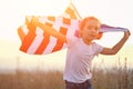 Cheerful girl runs across field holding USA flag behind back Royalty Free Stock Photo