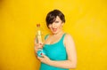 Cheerful girl with short hair with a big bottle of water on a yellow background in the Studio Royalty Free Stock Photo