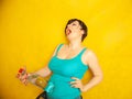 Cheerful girl with short hair with a big bottle of water on a yellow background in the Studio Royalty Free Stock Photo