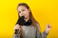 Cheerful girl sings into a microphone. Little Star, show business Royalty Free Stock Photo