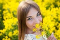 Cheerful girl smelling yellow wildflower