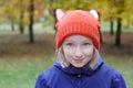 Cheerful girl smiling, the child is dressed in a funny knitted warm hat with ears, looks like a fox. Royalty Free Stock Photo