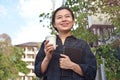 Cheerful girl standing outdoor holding paper cup with coffee