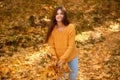 Cheerful girl student collects and throws fallen maple leaves into air in beautiful autumn park or forest. autumn vacation Royalty Free Stock Photo