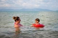 Cheerful girl swimming with her mom at sea