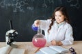 Cheerful girl taking part in chemistry experiment in the laboratory