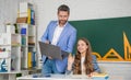 cheerful girl with teacher in classroom use laptop Royalty Free Stock Photo